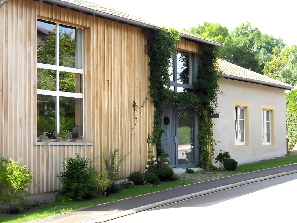 a house with ivy on the side of it at La Campagne in Saint-Hubert
