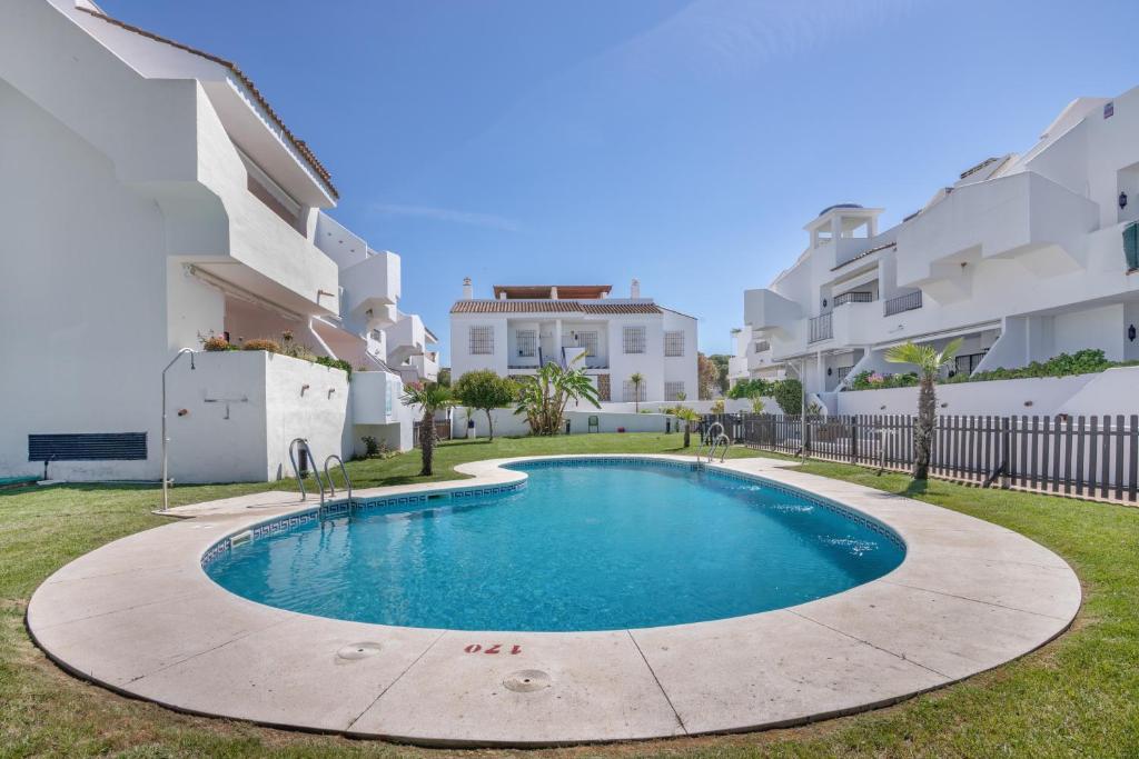 a swimming pool in front of some apartment buildings at Con piscina en playa Islantilla in Islantilla