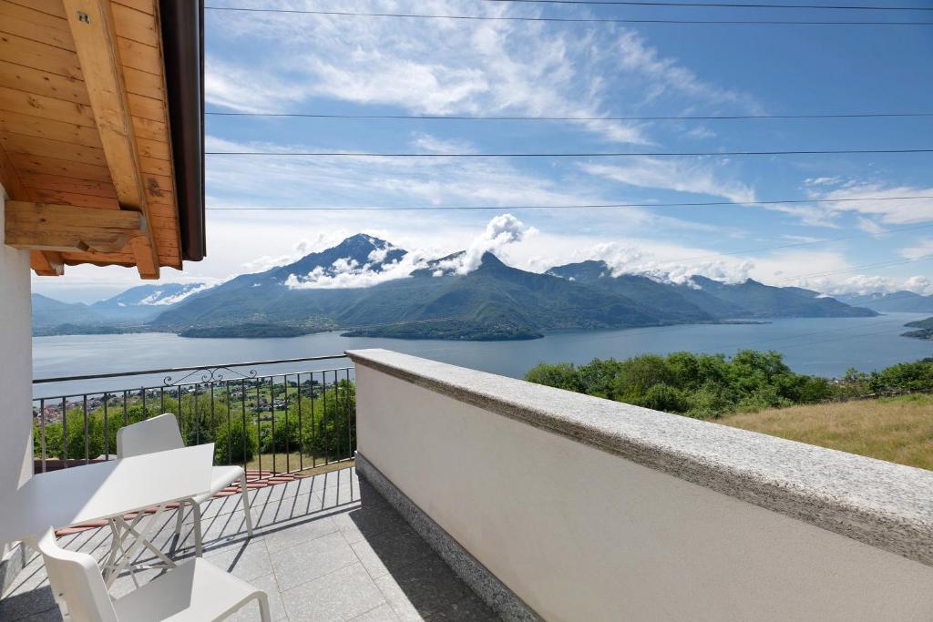 a balcony with a view of a lake and mountains at Il Nido Del Colibrì in Stazzona