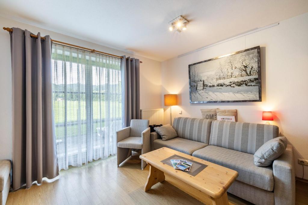 a living room with a couch and a table at Fewo Brünnstein - Nr 13 Pool, Sauna in Oberaudorf