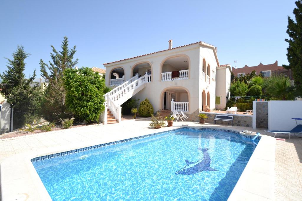 a villa with a swimming pool in front of a house at Casa Papa in San Fulgencio