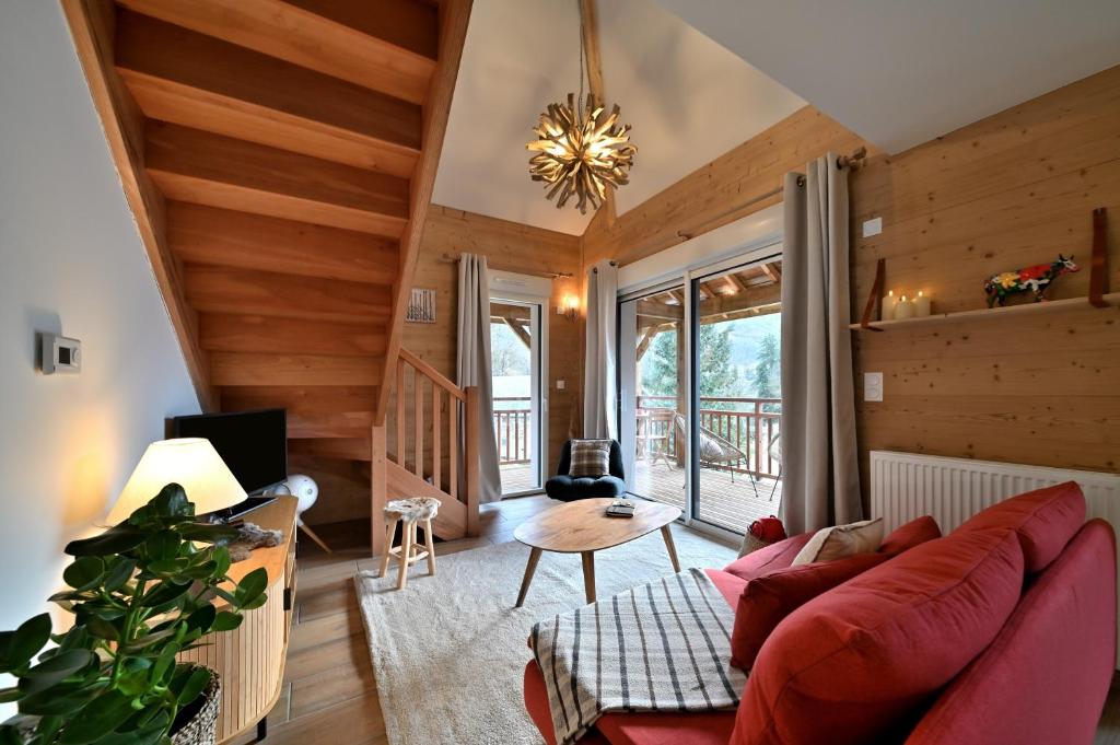 a living room with a red couch and wooden walls at Superbe appartement - Face au lac in Génos