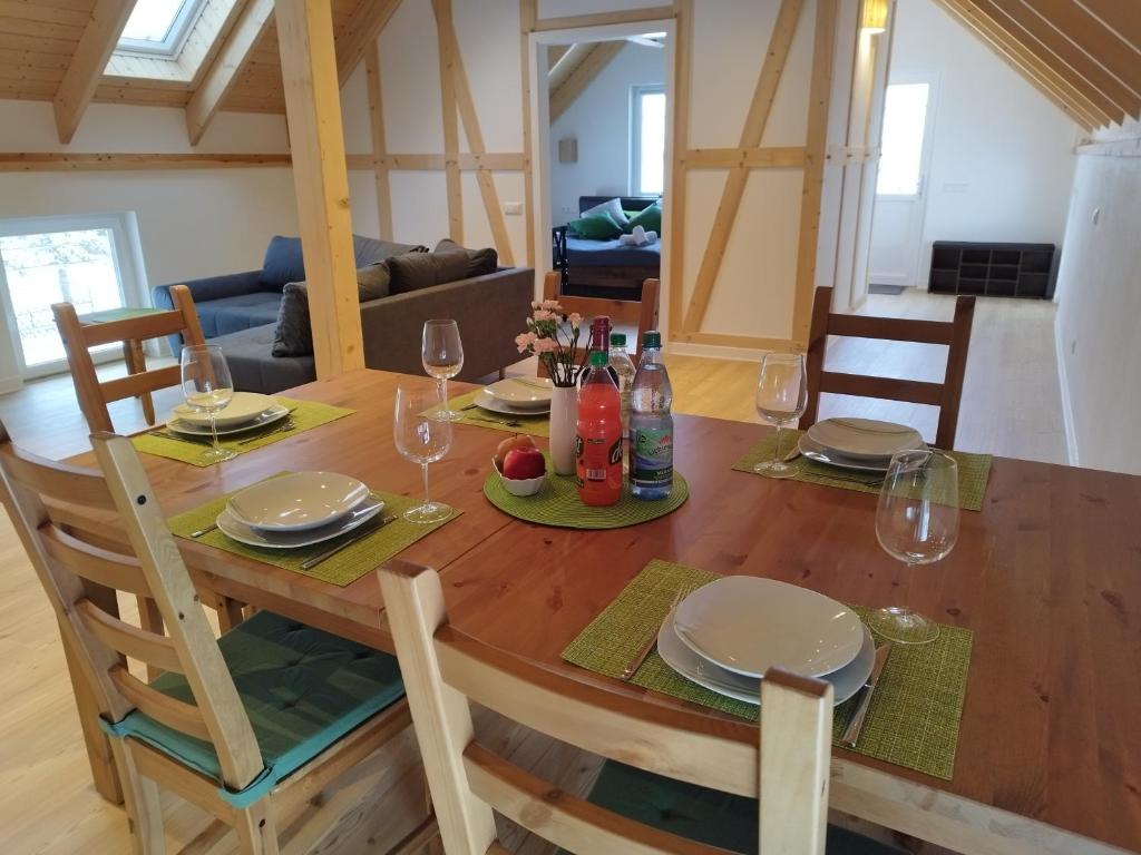 a wooden table with wine glasses and plates on it at Kleine Auszeit 1 in Forst