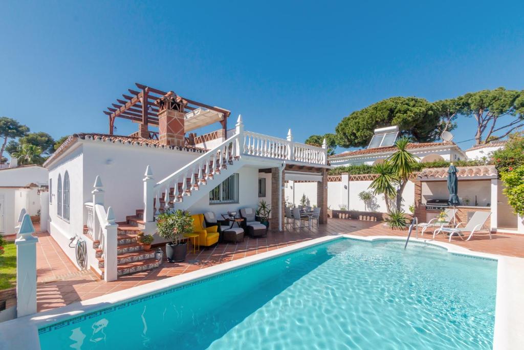 a villa with a swimming pool and a house at Villa Costabella in Marbella