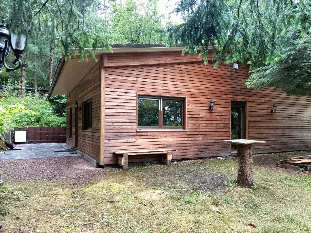 a log cabin with a bench in front of it at Waldhaus Hempe in Tabarz