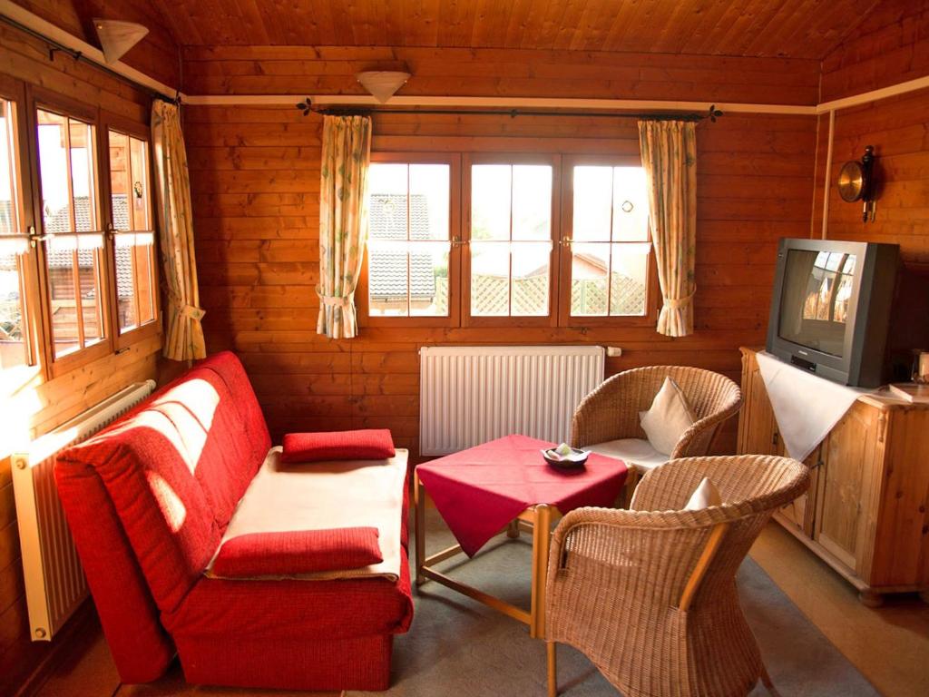 a living room with a couch and a table and a tv at Ferienhaus Pöttgen in Arnsberg