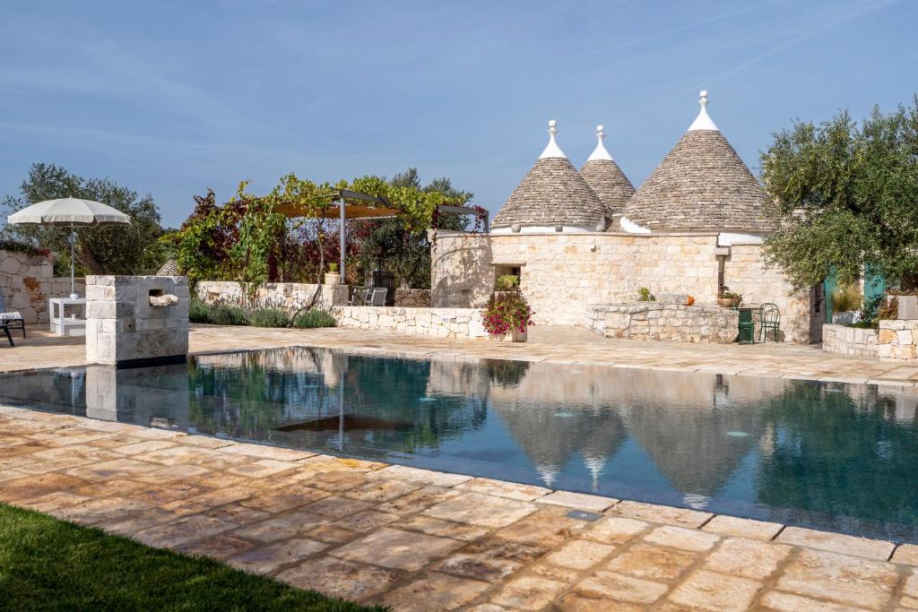 a swimming pool in front of a house at Trulli Orma in Martina Franca