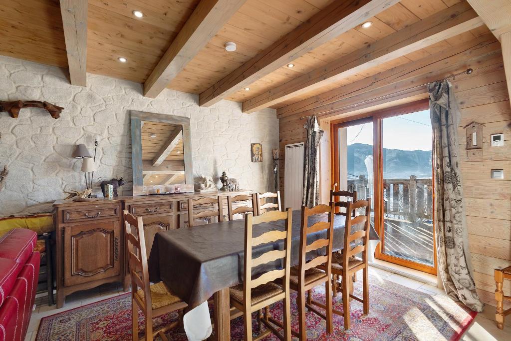 a dining room with a table and chairs and a window at Maison de village Puyvalador in Puyvalador