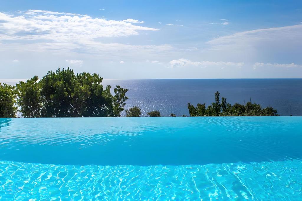 a swimming pool with the ocean in the background at Les Hauts de Figha in Conca