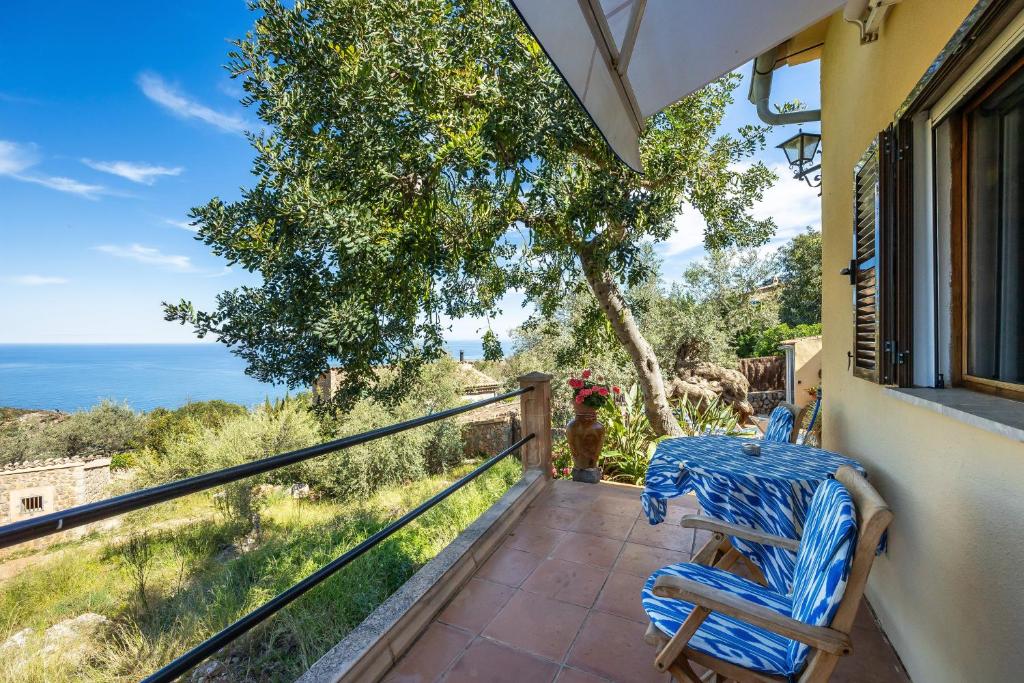a patio with a table and a chair on a balcony at Es Porcho in Deia