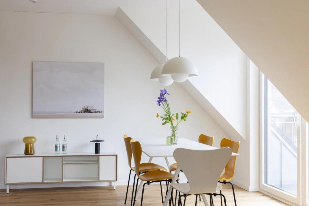 a dining room with a white table and chairs at Strand in Böhl