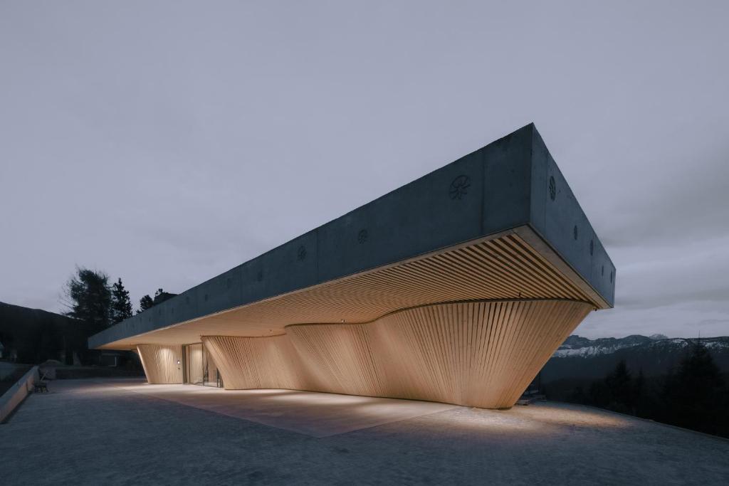 a building with a wooden facade at dusk at anders mountain suites 2 in Brixen