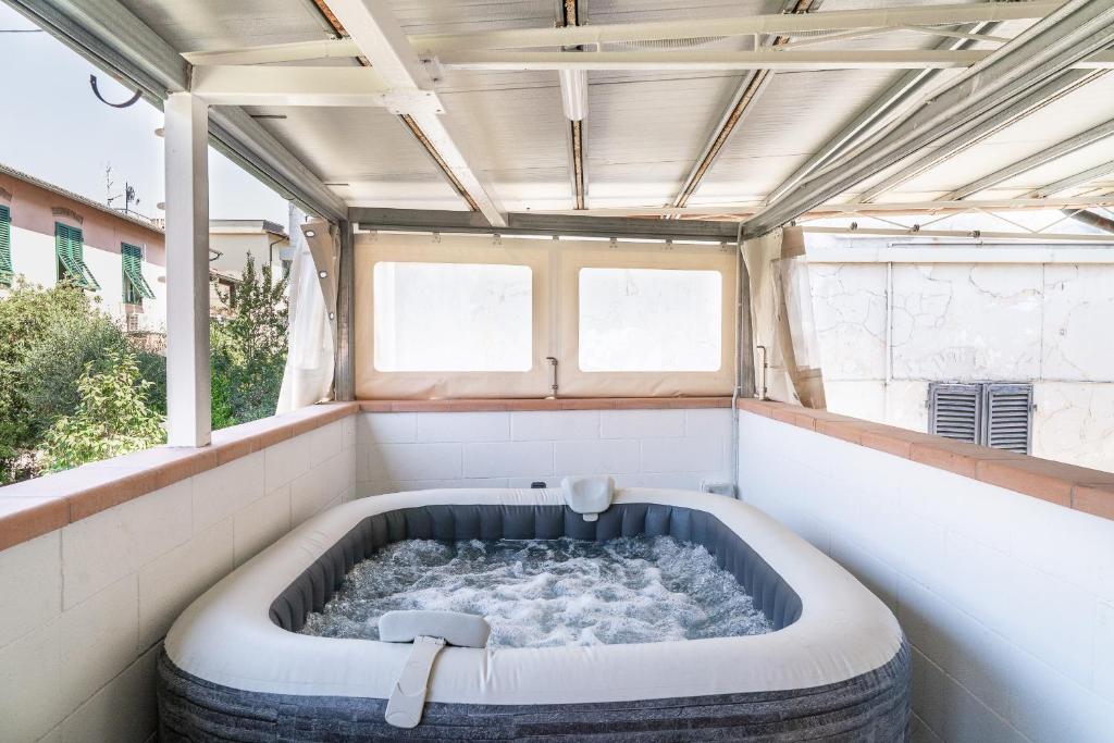 a large tub in a room with a window at La Corte Rurale con jacuzzi in Lucca