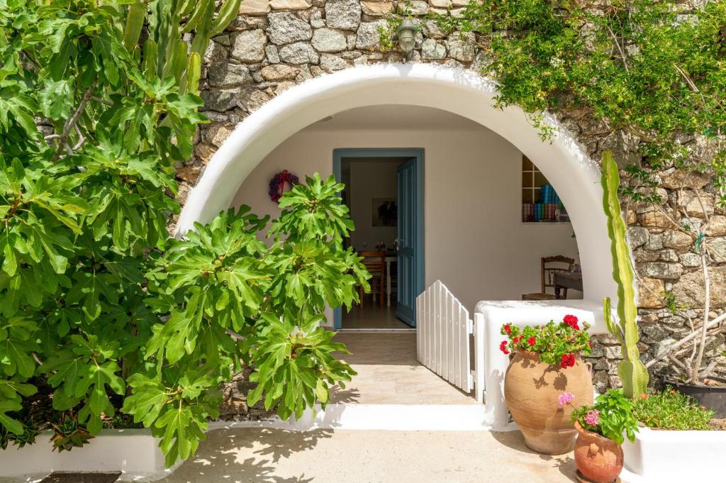 an archway leading to a house with plants at Afroditi Ftelia Gerani A in Mykonos