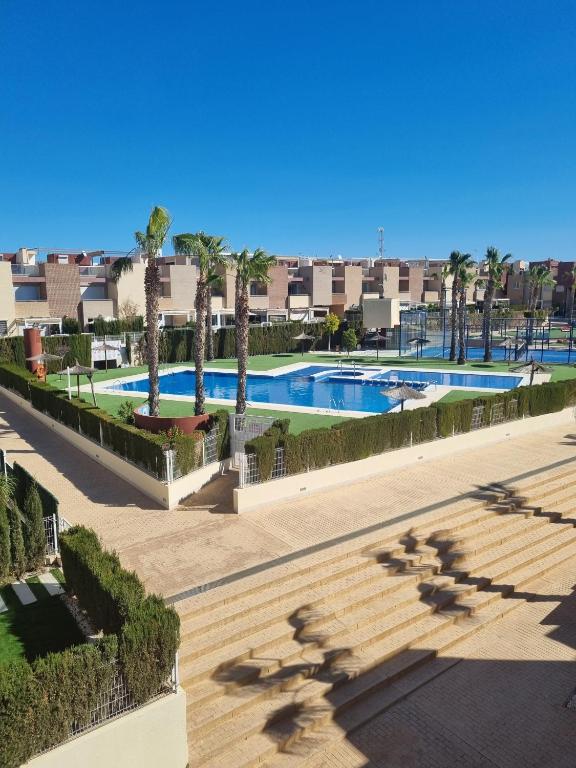 a resort with a swimming pool and palm trees at Fantastic apartment in Torrevieja
