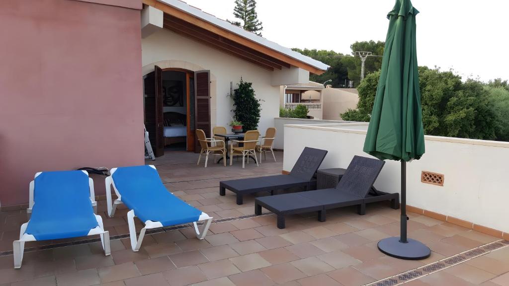 a patio with two chairs and an umbrella at Casa las Columnas in Capdepera