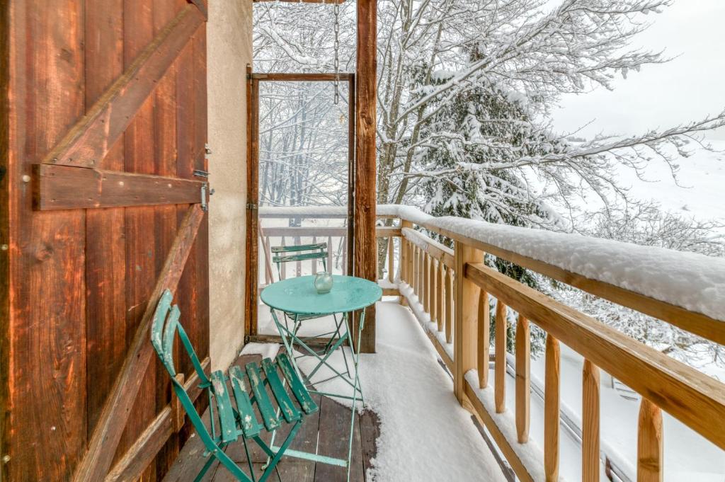 a table and chairs on the balcony of a cabin at Le Flocon Grand Chalet 4 étoiles in Villard-Reculas