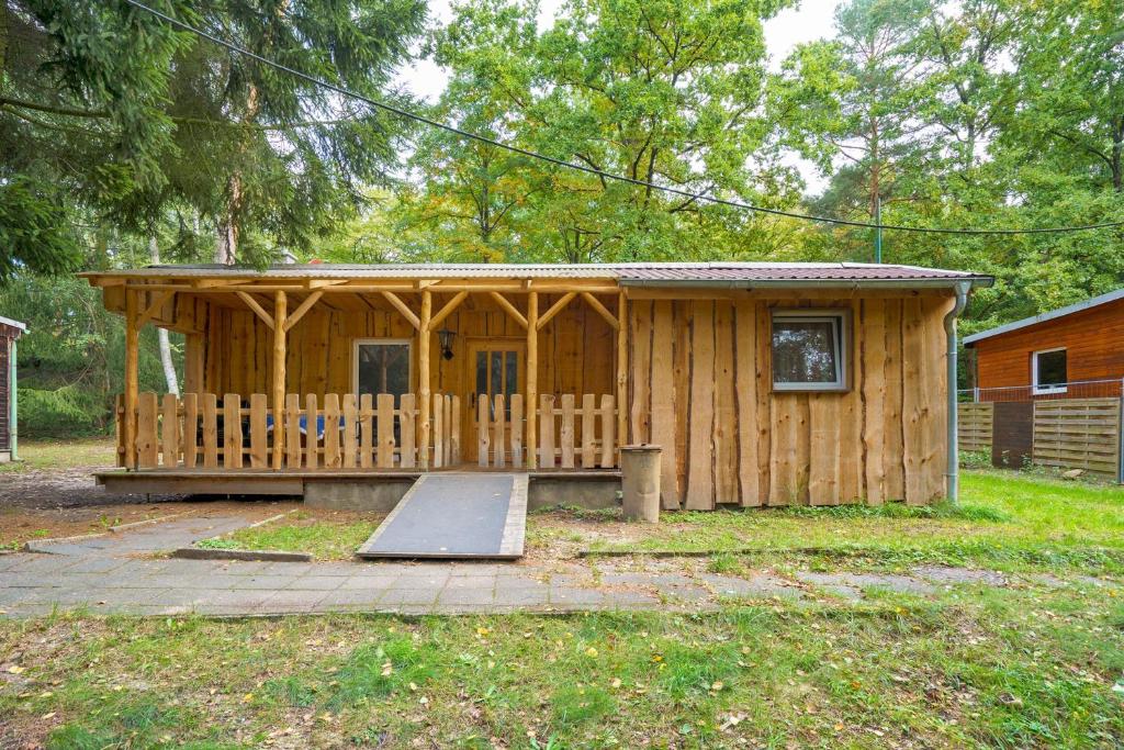 a wooden cabin with a ramp in front of it at Bungalow 19 - Finnhütte in Niesky
