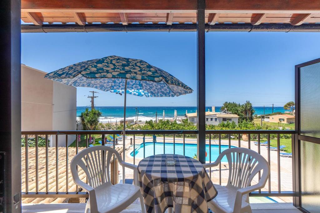 a patio with a table and chairs and an umbrella at Mires House Front Studio 1 in Agios Gordios