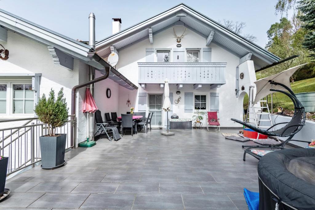 a white house with a balcony and a patio at Ferienwohnung Plötz in Bad Koetzting