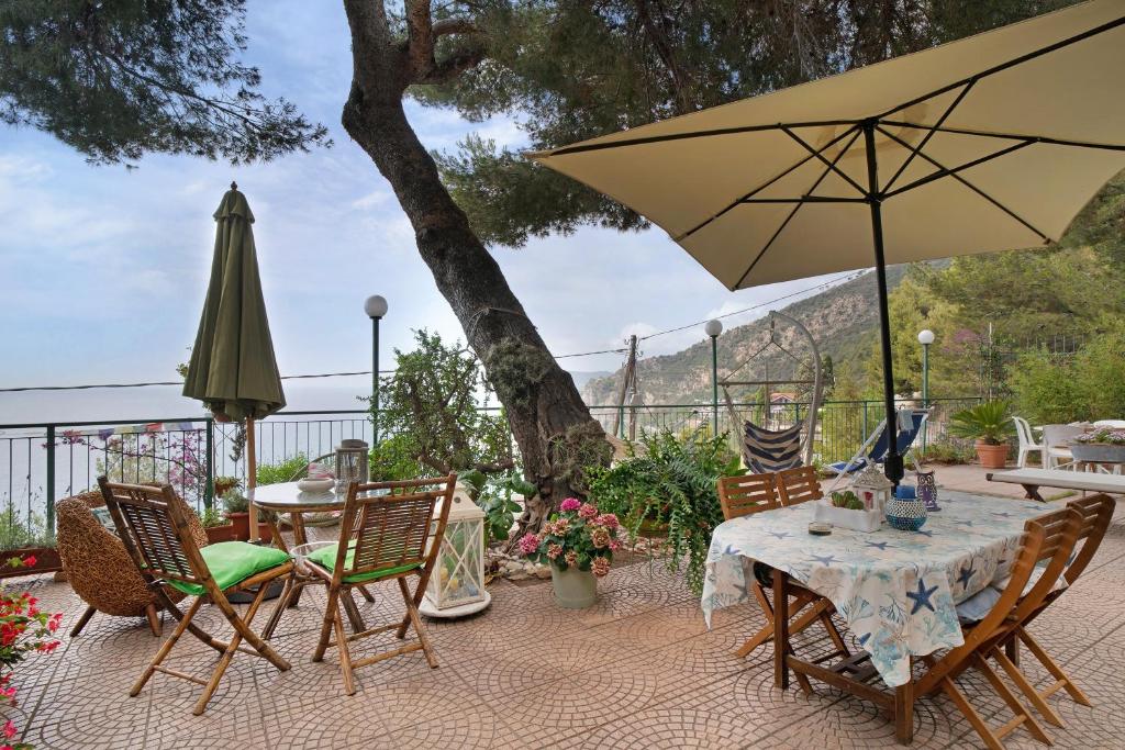 a patio with a table and chairs and an umbrella at Oasi in Alassio