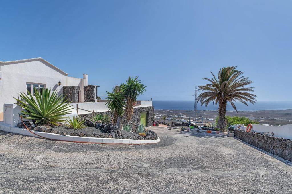 a house with palm trees and a gravel driveway at Casa Eden in Tías