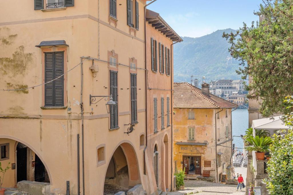 an old building in a town with a mountain in the background at Antro Di Circe - Orta Centro in Orta San Giulio