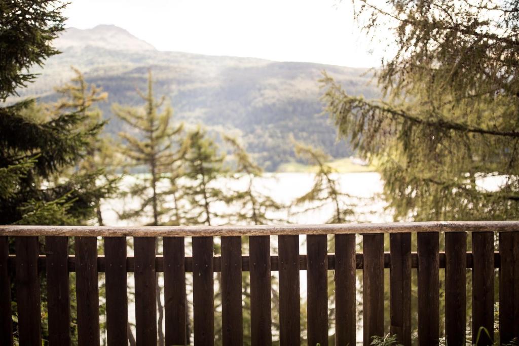 a wooden fence with a view of a snow covered mountain at Chalet am Reschensee in Resia