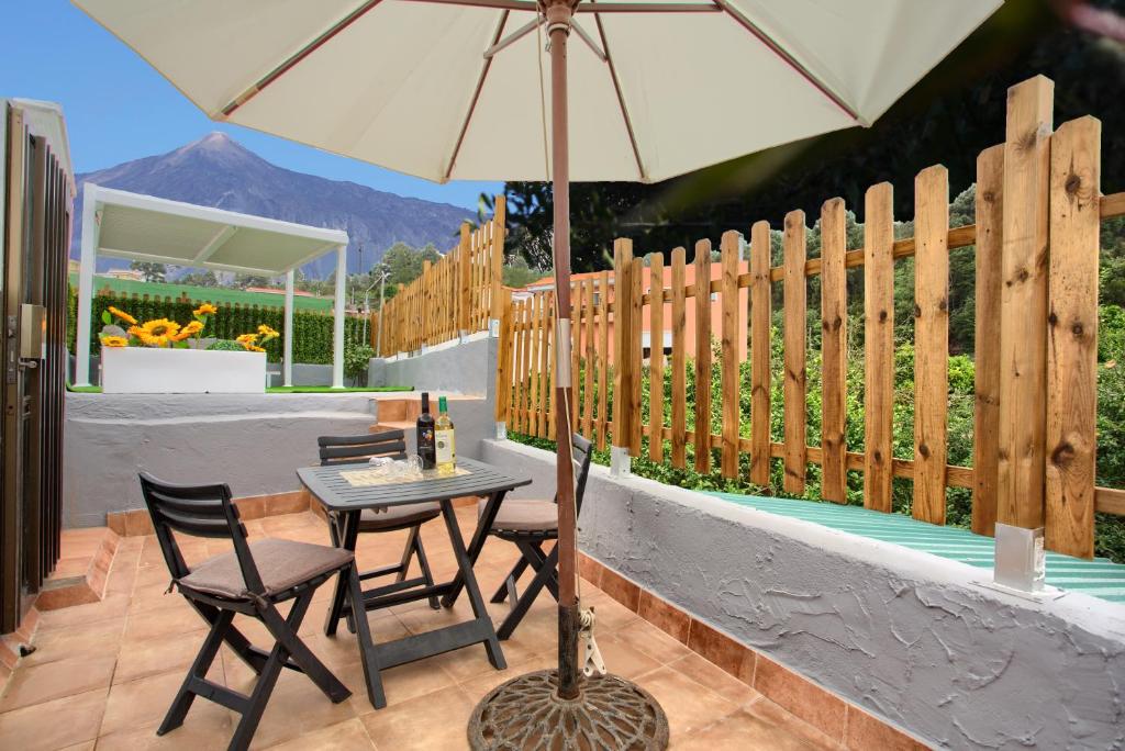 a table and chairs with an umbrella on a patio at Los Abuelos 2 Icod in Icod de los Vinos