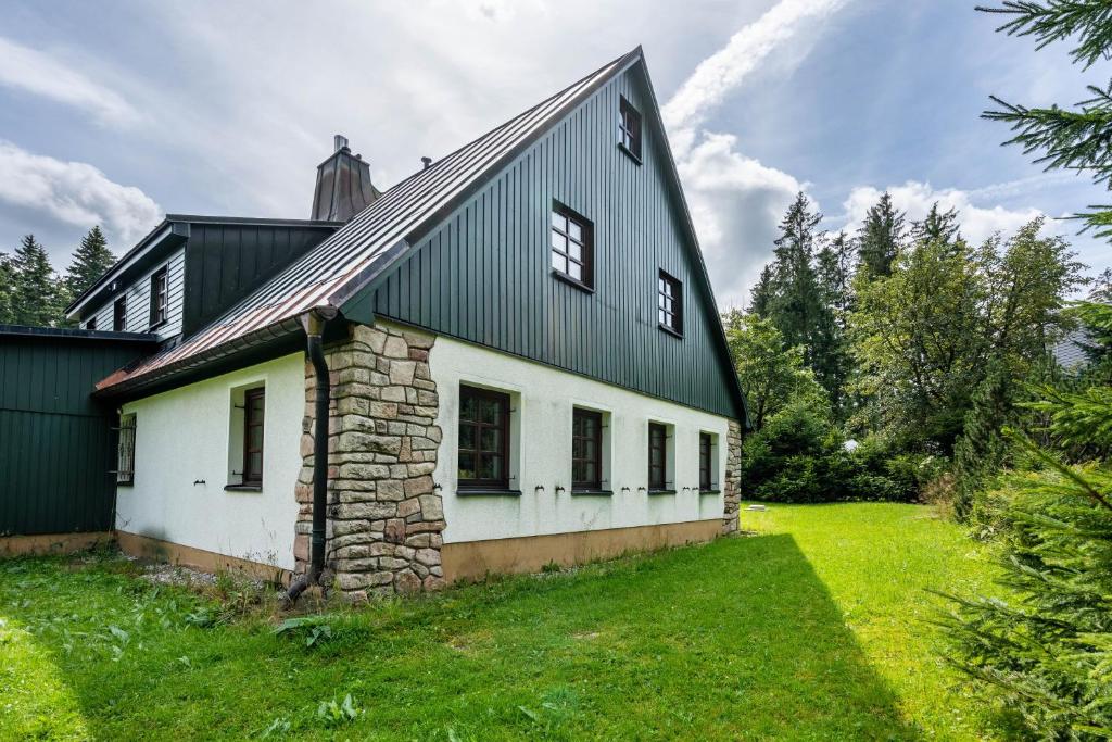 an old stone house with a black roof at Ferienhaus Henneberg in Johanngeorgenstadt