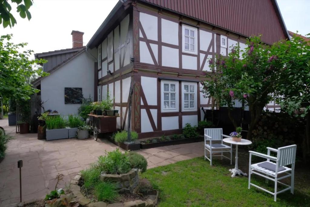 a house with a patio and a table and chairs at Beim Bildhauer Karl F in Trendelburg