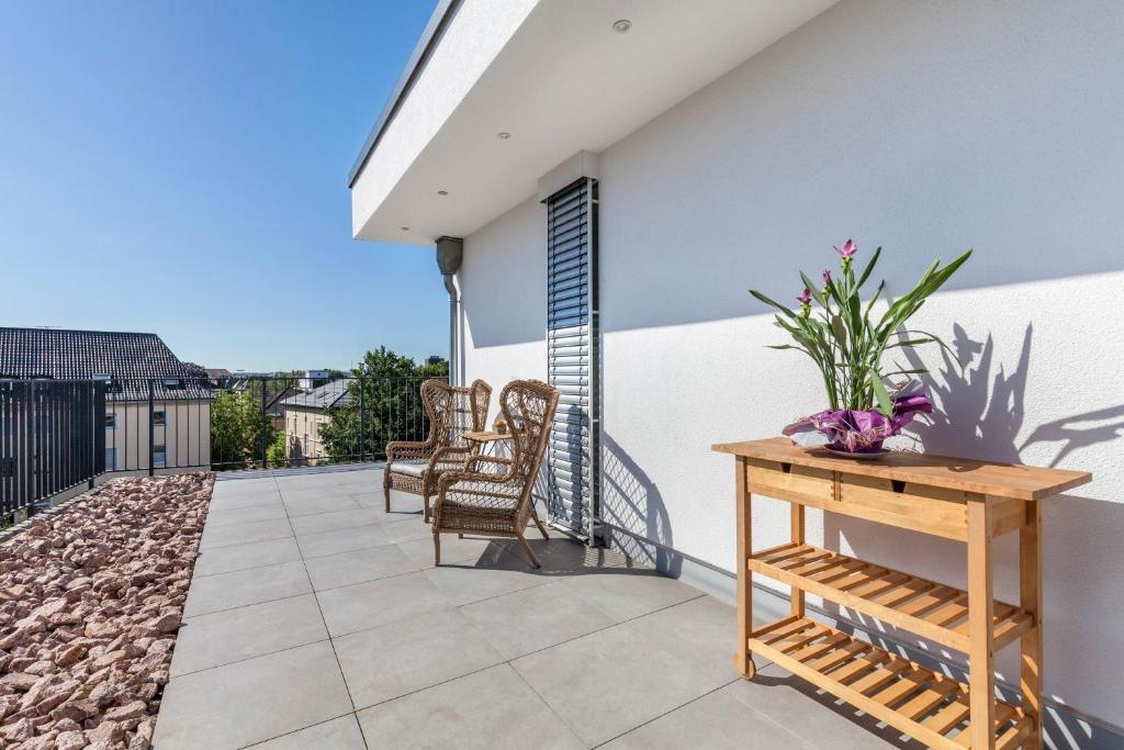 a patio with chairs and a table on a house at Modern, Cityview, Penthouse Yiwoo in Gießen