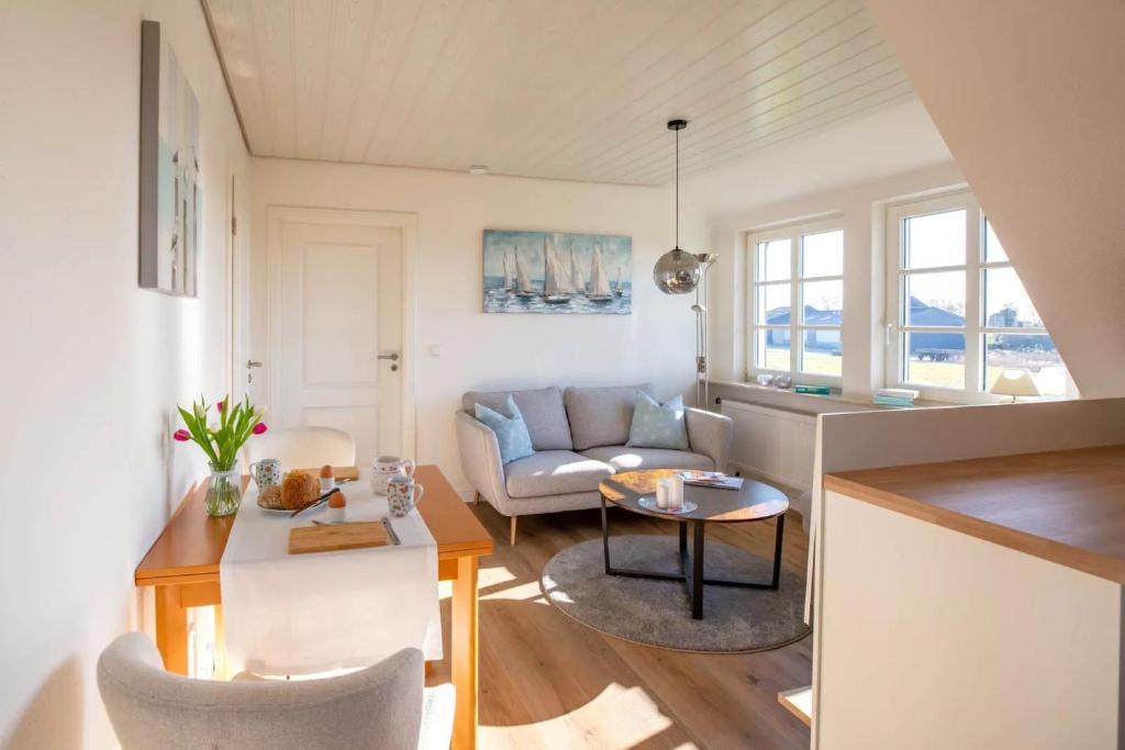 a living room with a couch and a table at Urlaub an der Nordermühle in Pellworm