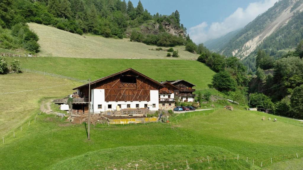 a house on a green field with a hill at Ausser Brugghof in Senales