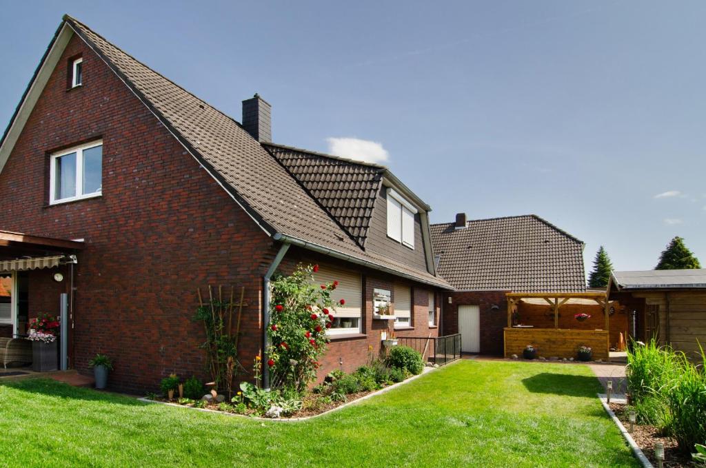 a red brick house with a green yard at Ferienwohnung Goesmann in Zetel