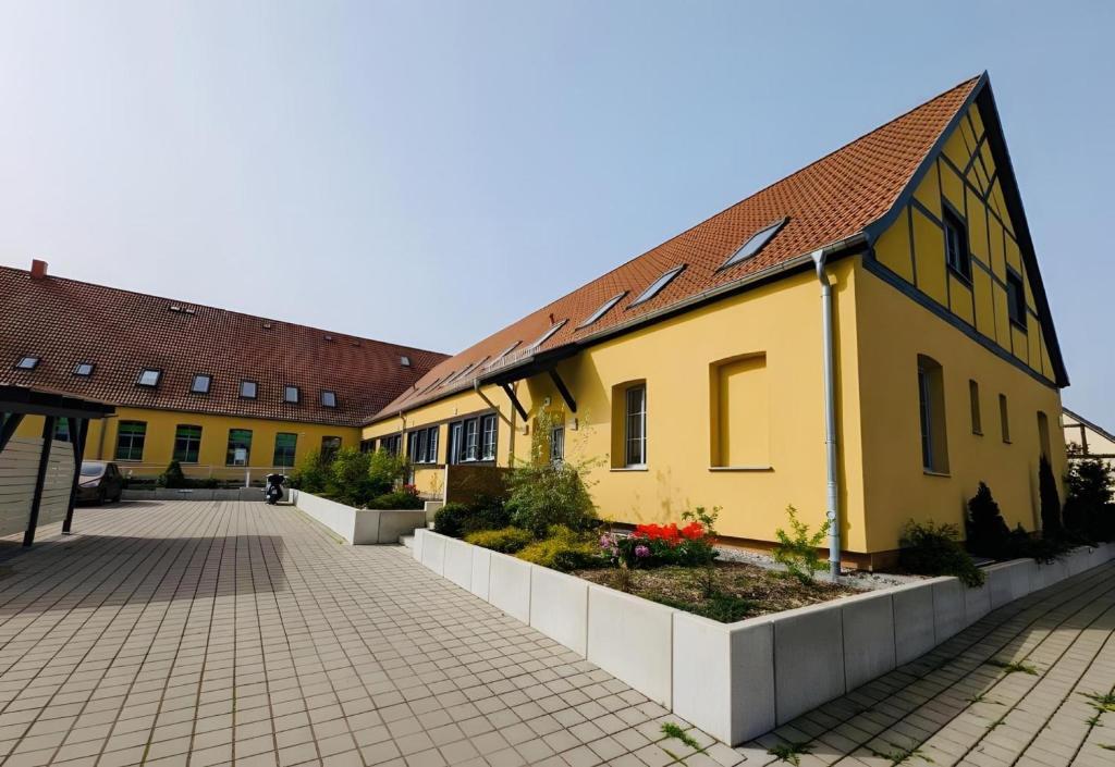 ein gelbes Gebäude mit Ziegeldach in der Unterkunft Fewo-Romuli in Eggesin