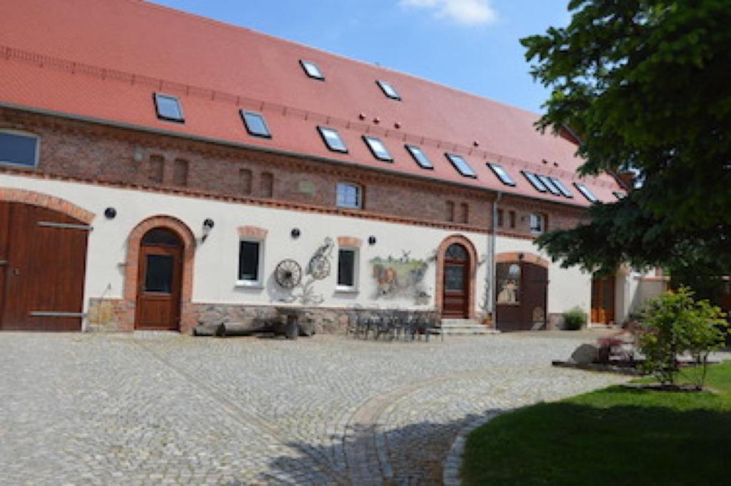 a large brick building with a red roof at Ferienwohnungen Bunge in Krostitz