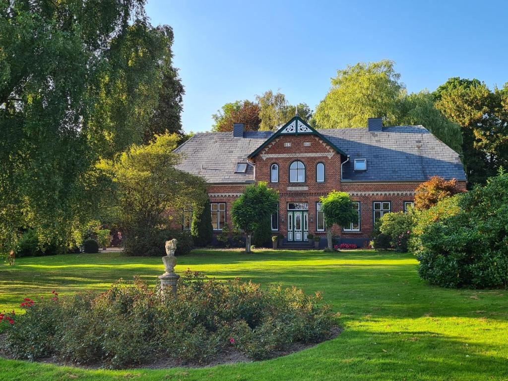 a large red brick house with a green yard at Ferienwohnung Haloi in Torsballig