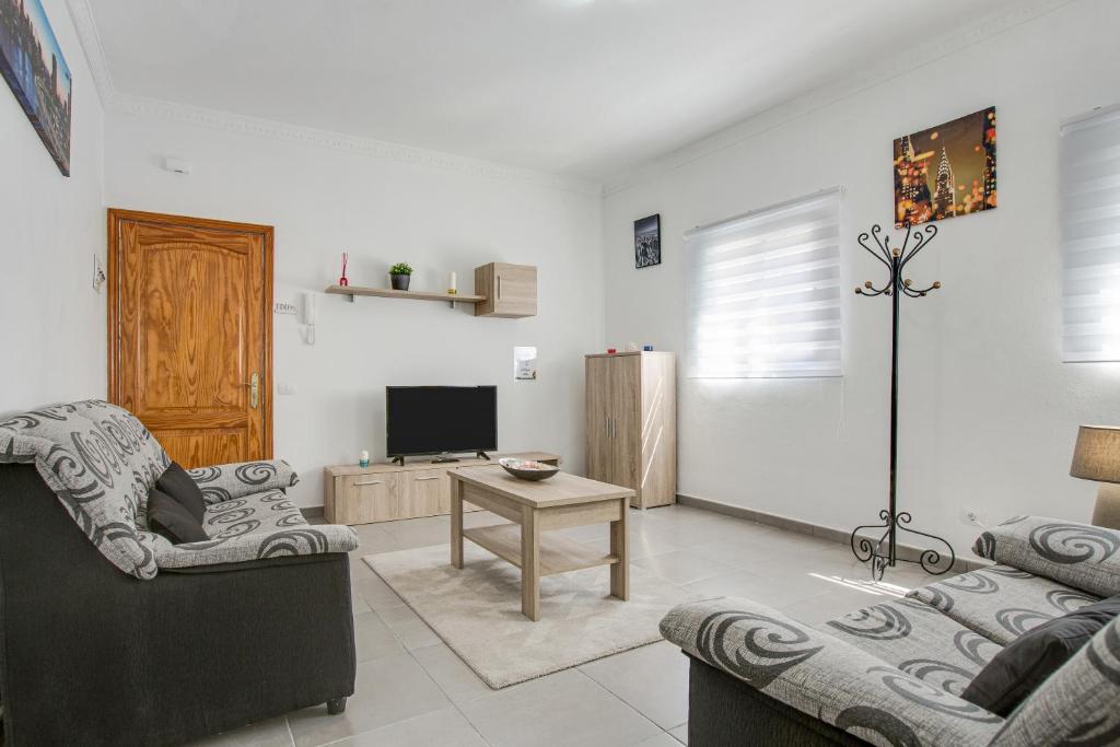 a living room with two chairs and a television at 2a Francesca in Vecindario
