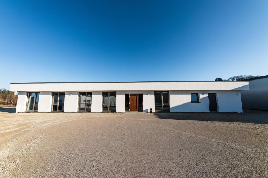 ein großes weißes Gebäude an einer unbefestigten Straße in der Unterkunft Boardinghouse27 in Dußlingen
