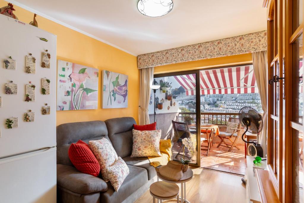 a living room with a couch and a table at Bungalow Flores with view in Puerto Rico de Gran Canaria