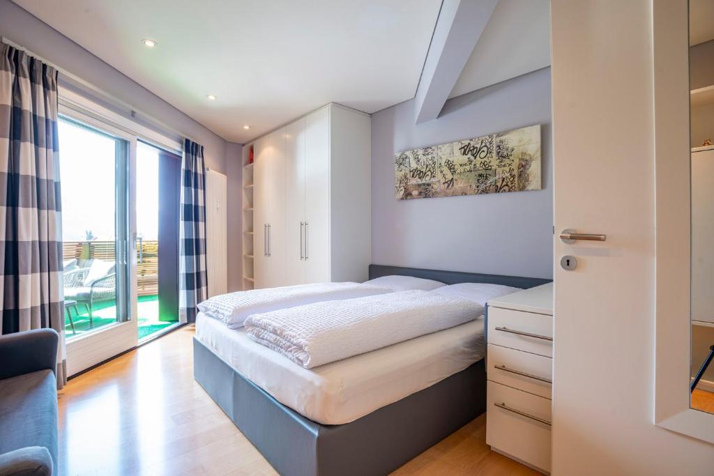 a bedroom with a bed and a large window at Tubris Living in Sand in Taufers