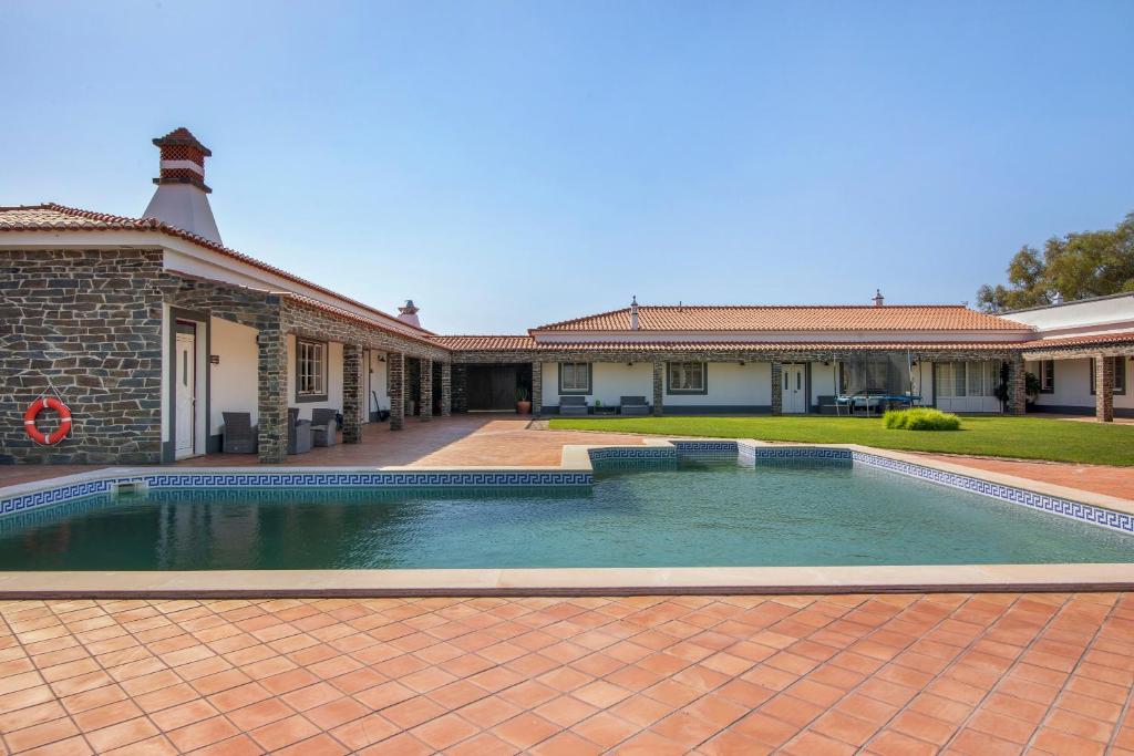 a swimming pool in front of a house at Casas do Monte in Giões