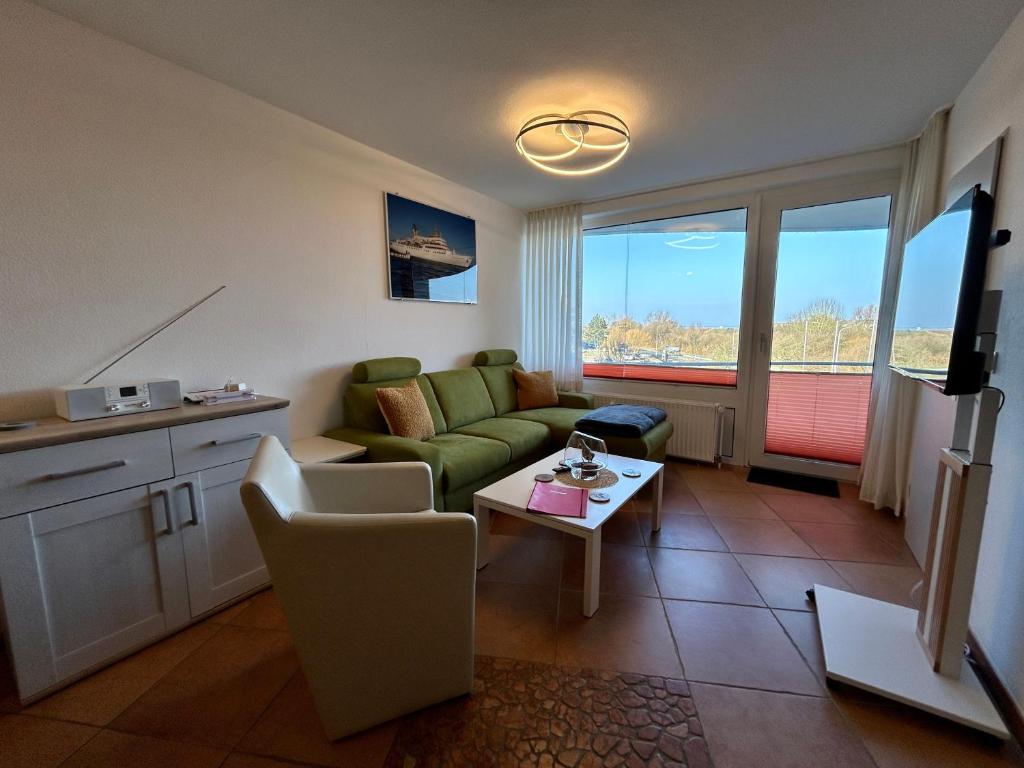 a living room with a green couch and a table at 208 im Lord Nelson in Cuxhaven