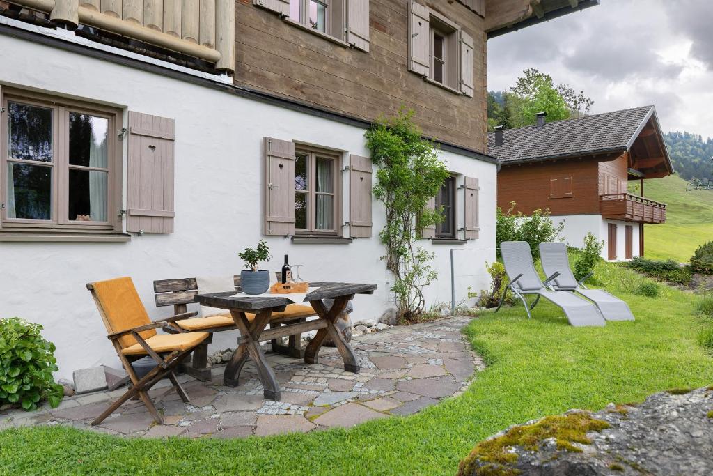 a patio with a table and chairs in front of a house at Haus Verdandi in Sibratsgfäll
