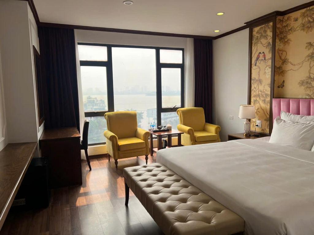 a hotel room with a bed and two chairs at Hanoi Central Westlake Hotel in Hanoi