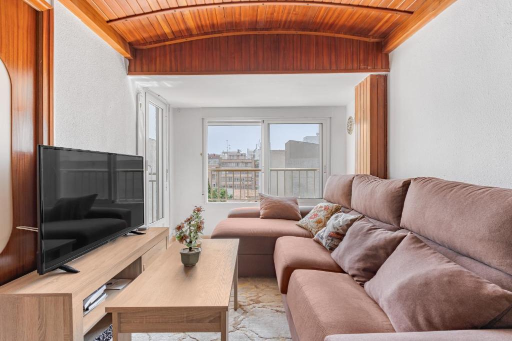 a living room with two brown couches and a flat screen tv at Calle Apolo 3 in Torrevieja