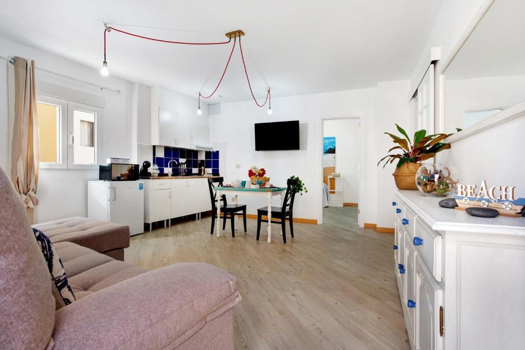 a living room and kitchen with a couch and a table at Holidays Maxorata Relax in Gran Tarajal