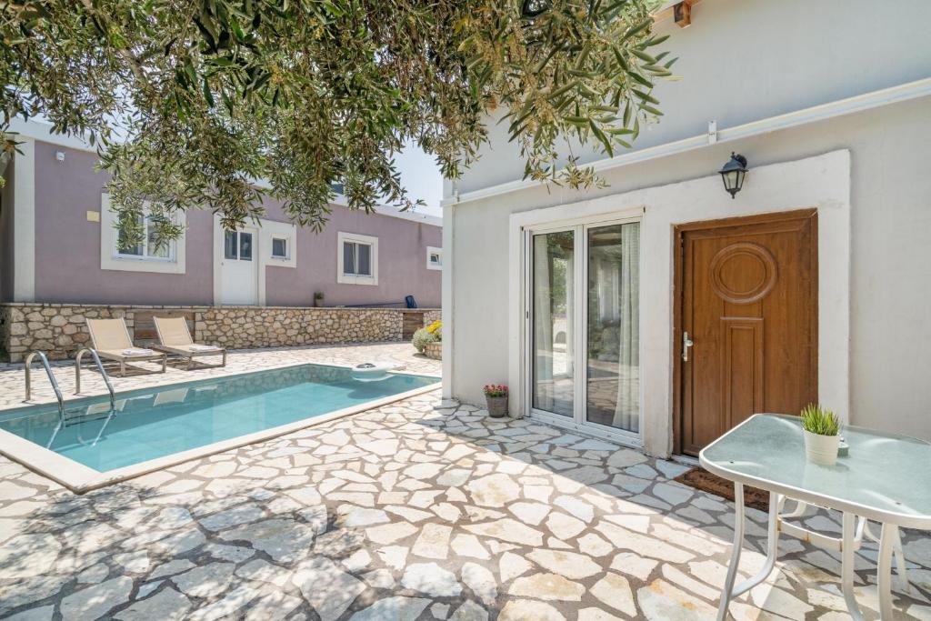 a villa with a swimming pool and a house at Stathis Suite in Exanthia