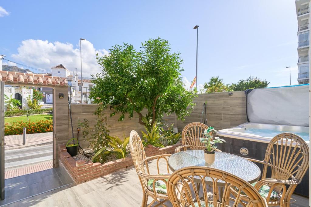 a patio with a table and chairs on a balcony at Casa Ramos Con Jacuzzi in Nerja